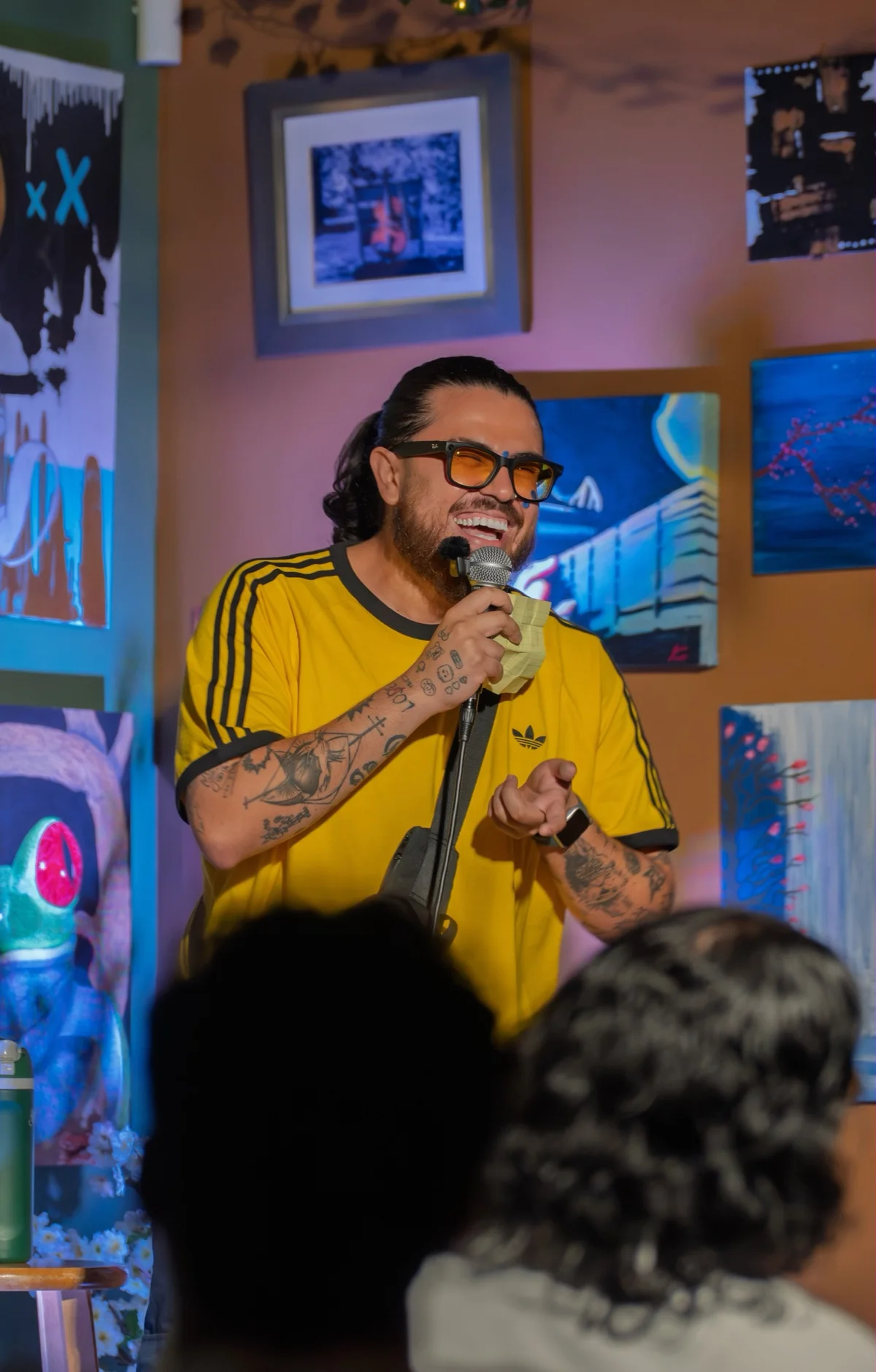 A performer in a yellow shirt speaking to an audience